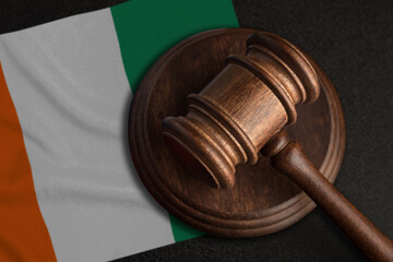Judge gavel and flag of Cote d'Ivoire. Law and justice in Cote d'Ivoire. Violation of rights and freedoms