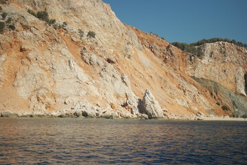Fototapeta na wymiar Sandstone rock formation at Mediterranean sea coast. Blue sea water, sandstone rock formartion and clear blue sky in the background.