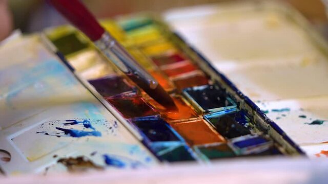 Applying paint to the brush from the palette