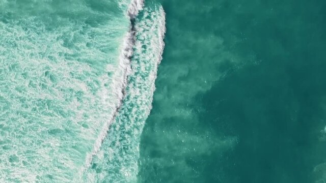 Drone view of the ocean with waves crashing