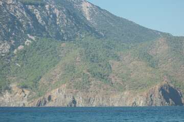 Fototapeta na wymiar Blue sea and mountain with green vegetation. Beautiful green mountains and sea landscape.