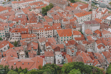 Top view on Kotor old town, red roofs and streets with tiles and stone buildings.
