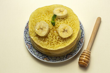 Homemade traditional moroccan baghrir with honey, strawberries and mint from above