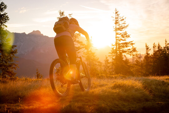 A mountain biker is doing off-road moutain biking early morning at sunrise.