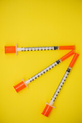 Fototapeta premium Insulin syringe on a yellow background