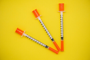 Insulin syringe on a yellow background