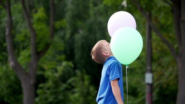 Little boy with balloons. Happy kid having fun with balloons in summer park