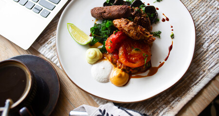 White plate of tomato with meat and herbs served on table