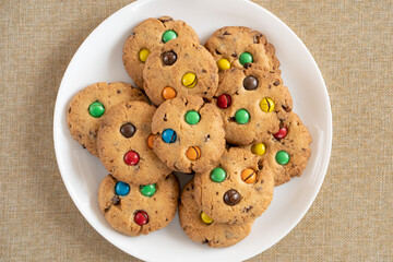 Cookies with colorful M&Ms chocolates close-up on a white ceramic plate.