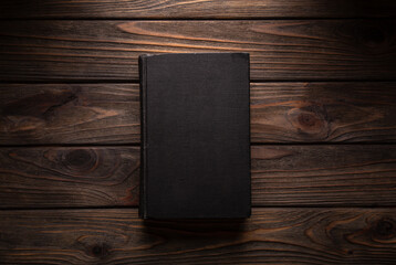 Closed book on vintage wooden background.  Old book on the wooden table. Closed book with empty...