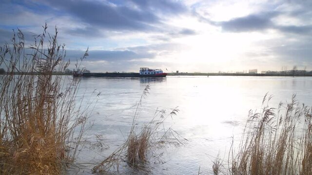 Ship sailing on the river Ijssel with high water level in Overijssel, The Netherlands.