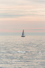 Naklejka na ściany i meble Sailing boat on the Black Sea at sunset in Sochi, Russia