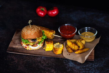 Fototapeta na wymiar Food background of grilled hamburger on wooden board.Delicious fresh tasty homemade beef burger with cutlet cheese and ketchup. Craft beef burgers with vegetables.
