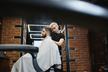 Close-up, master hairdresser does hairstyle and style with scissors and comb. Concept Barbershop.