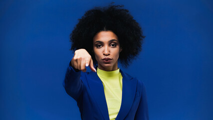 Fototapeta na wymiar Young african american woman pointing with finger at camera on blurred foreground isolated on blue