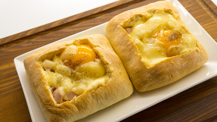 Baked Egg Ciabatta Boats. ciabatta with egg on a wooden plank 