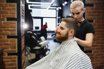 Close-up, master hairdresser does hairstyle and style with scissors and comb. Concept Barbershop.