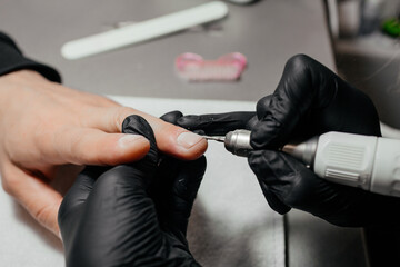 Men's manicure. Design of men's manicure. The master makes a man manicure. The concept of professional nail care. Close-up of the manicurist's hands at work. A man does a manicure.