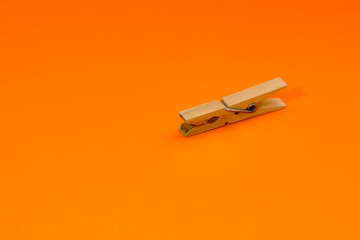 Set of wooden clothespins that appear one by one on an orange background.
