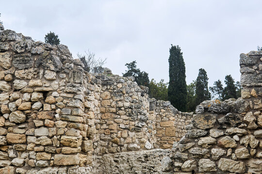 antique ruins - remains of stone walls among cypresses