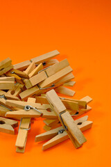 Set of wooden clothespins that appear one by one on an orange background.
