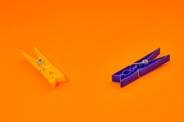 Set of colorful clothespins appearing one by one on an orange background.