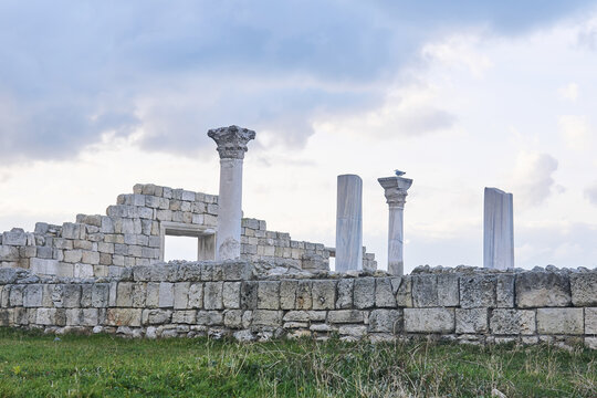ruins of antique greek temple with columns against a winter sky