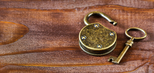 Escape room game concept, old vintage golden key and padlock. Web banner with copy space.