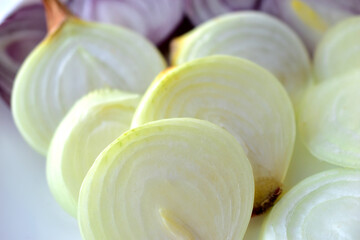 Blue and yellow onion cut into round pieces on a white plate