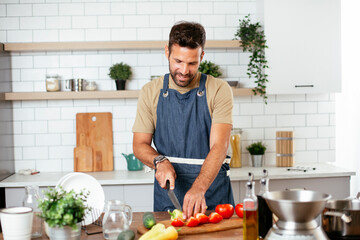 Handsome man preparing vegetable salad in the kitchen. Healthy Food. Vegan Salad.