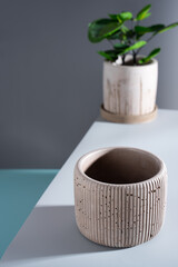 Creative diagonal Composition with concrete pink flower pot. on a blue background. Minimalism. Natural material. DIY. Eco-friendly.