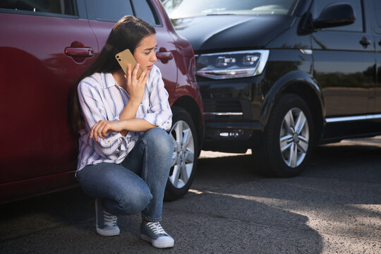 Stressed Woman Talking On Phone After Car Accident Outdoors