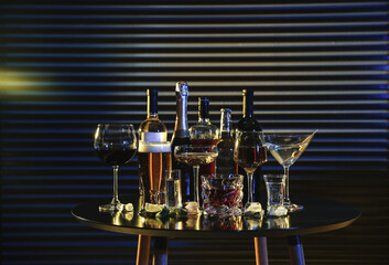 Fototapeta na wymiar Many different alcoholic drinks on table against dark background