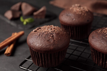 Delicious chocolate muffins on black table, closeup