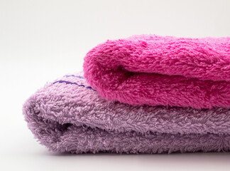 Obraz na płótnie Canvas Pink and purple towels. They stand in the bathroom and are used to wipe hands and other parts of the body.