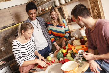 Fiends preparing vegetarian meal.They preparing food and making fun in the kitchen.Home party.
