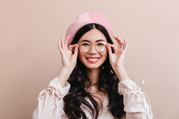 Naklejka premium Excited japanese girl posing in glasses. Beautiful asian woman in beret laughing at camera.