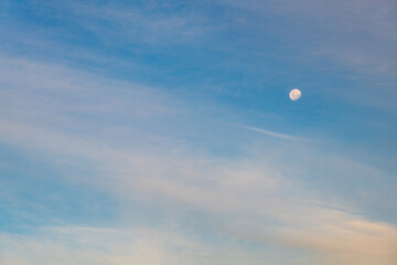 White clouds and the moon in a blue sky