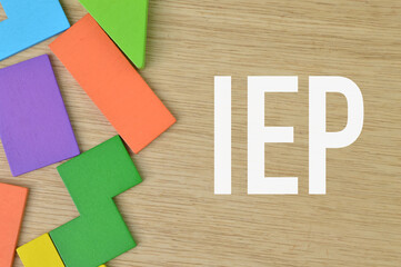Wooden background written with IEP stands for Individualized Educational Program.