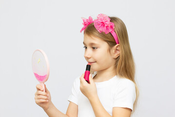 little cute girl with lipstick on white background