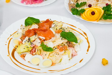 serving salad. salad in a restaurant on a table with a white tablecloth. Table served with dishes for the holiday 