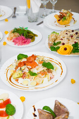 serving salad. salad in a restaurant on a table with a white tablecloth. Table served with dishes for the holiday 