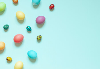 Colorful painted Easter eggs on the blue background. Top view. Copy space