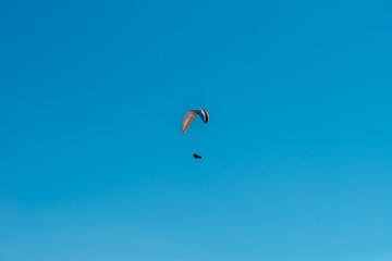 Man flying on a paraglider against the blue sky
