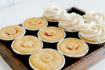 freshly baked cupcakes with strawberry-berry filling and white cream cheese on a wooden tray.Food for breakfast. Freshly baked cupcakes for dessert. Foodies and cuisine.