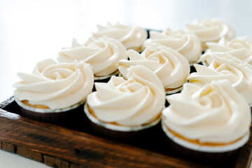 freshly baked cupcakes with strawberry-berry filling and white cream cheese on a wooden tray.Food for breakfast. Freshly baked cupcakes for dessert. Foodies and cuisine.