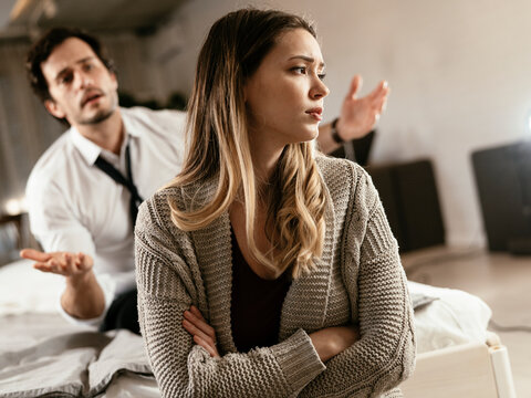 Boyfriend and girlfriend are arguing at home. Angry man is yelling at his sad girlfriend.