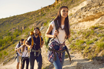 Group of friends tourists with backpacks traveler in the mountains on a hike hiking along the route...