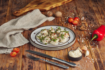 Italian ravioli pasta with greens, wooden background