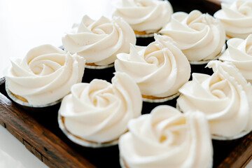 freshly baked cupcakes with strawberry-berry filling and white cream cheese on a wooden tray.Food for breakfast. Freshly baked cupcakes for dessert. Foodies and cuisine.